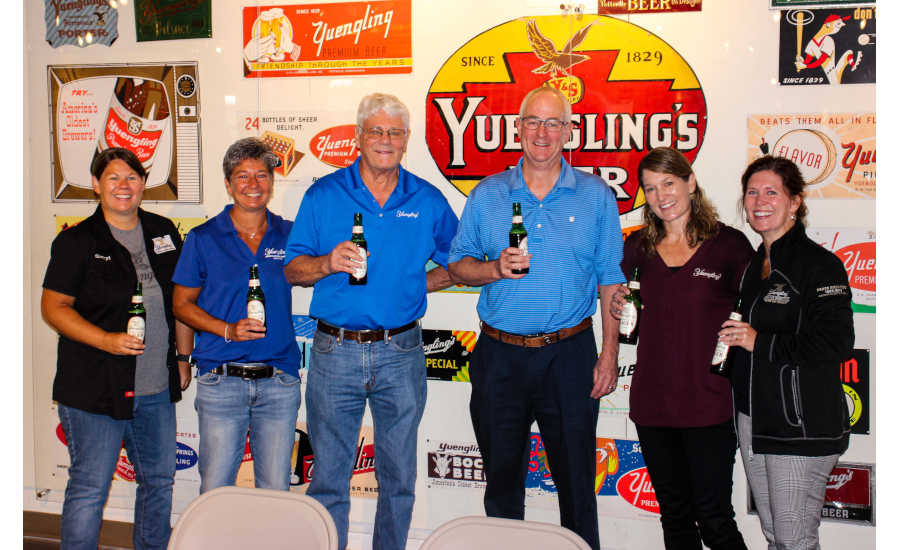 Group of people holding yuengling beer bottle in hand